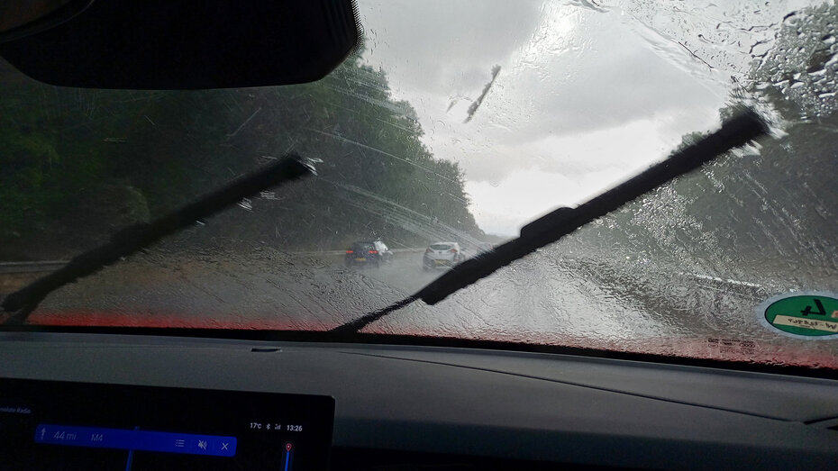 Innenansicht aus einem Auto, während es in Wales in Strömen regnet.