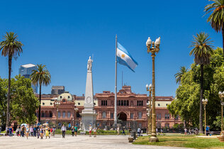 Platz mit Casa Rosada in Buenos Aires mit argentinischer Riesenfahne un dPalmen