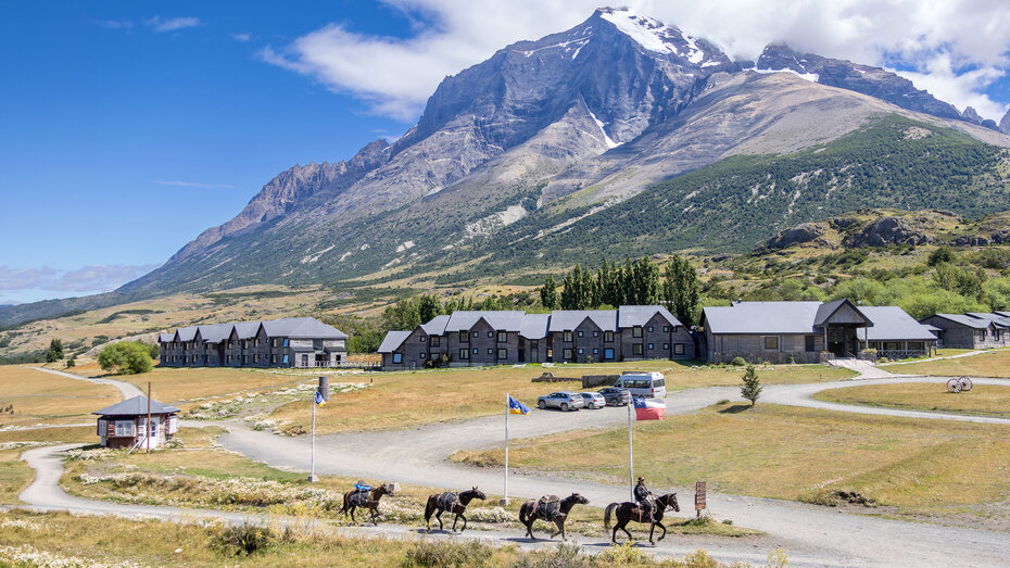 Blick auf das Hotel las Torres, dahinter ein schneebedeckter Berg, davor ein vorbeiziehender Reiter