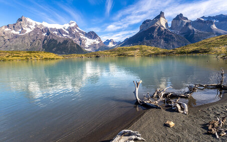 Blick über einen grünen See zum Bergmassiv Cuernos del paine