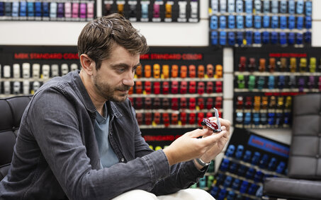 Craig Callum hält ein Spielzeugauto in seiner Hand