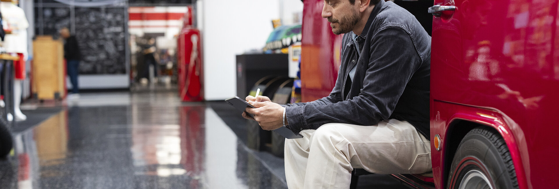 Craig Callum sitzt seitlich in einem alten roten VW Bus