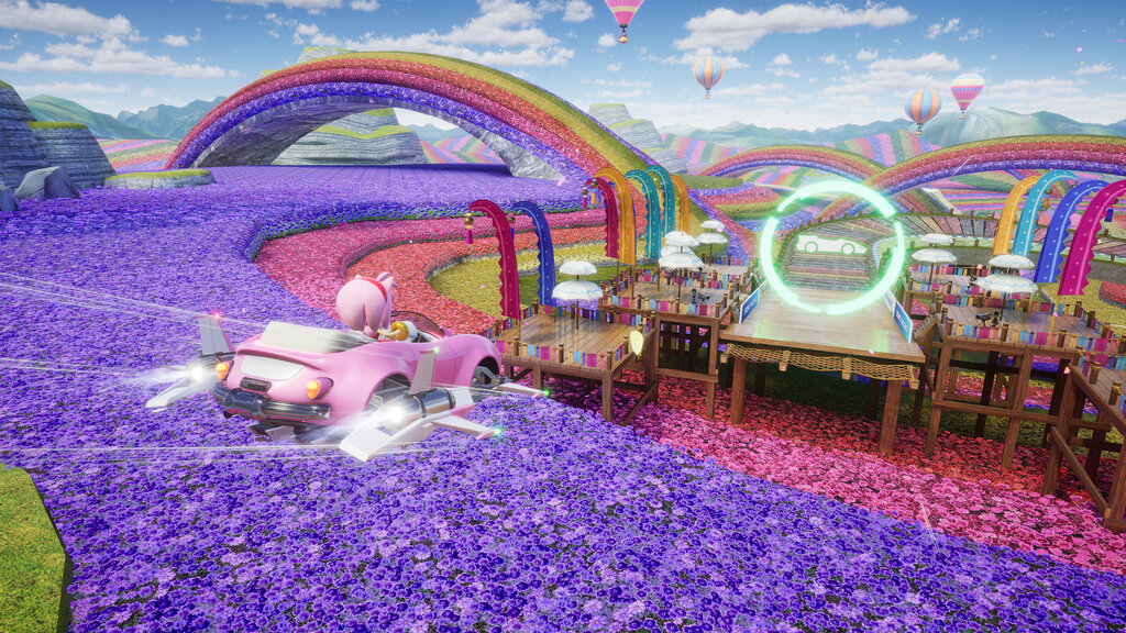 Screenshot aus Sonic Racing: Crossworlds. Amy auf Regenbogenstrecke.