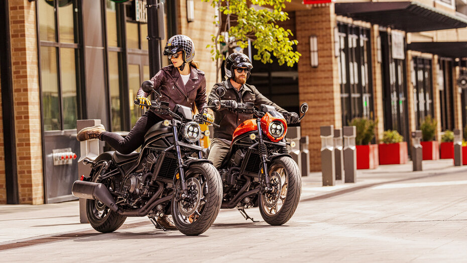 Eine Frau und ein Mann steigen auf ihre Motorräder auf