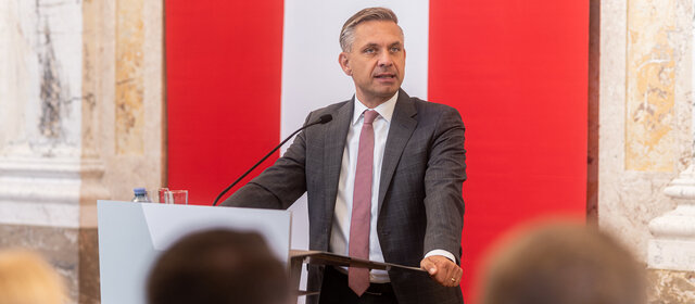 Wirtschaftsminister Hattmannsdorfer spricht an einem Redepult