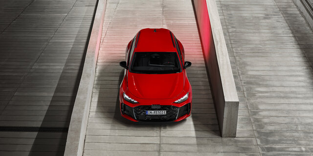 Eine roter Audi RS 5 Avant steht von oben fotografiert zwischen zwei Steinmauern.