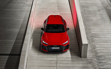 Eine roter Audi RS 5 Avant steht von oben fotografiert zwischen zwei Steinmauern.