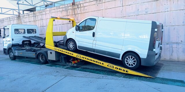 Ein Camping-Kastenwagen auf der Ladefläche eines Abschleppautos. 
