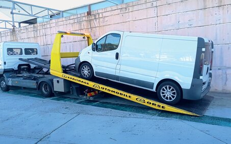 Ein Camping-Kastenwagen auf der Ladefläche eines Abschleppautos. 