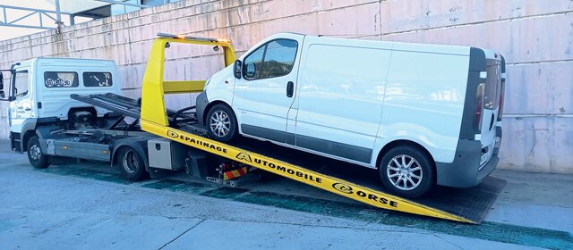 Ein Camping-Kastenwagen auf der Ladefläche eines Abschleppautos. 