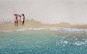 Familie am Strand liegen von oben