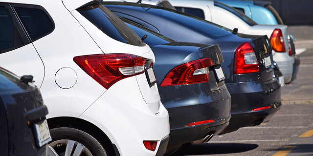 Die Hecks von mehreren nebeneinander stehenden Autos auf einem Parkplatz