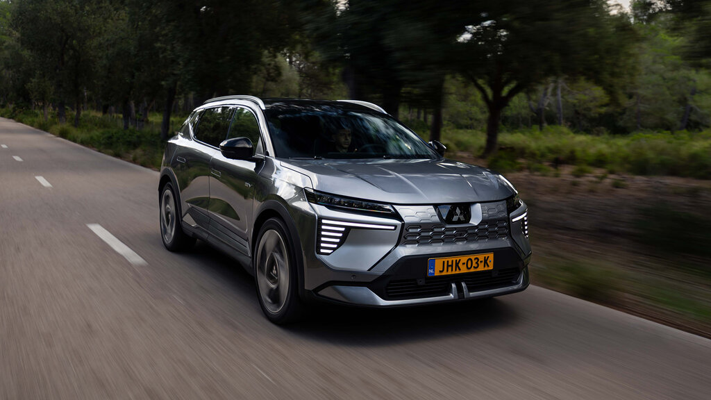 Ein silberner Mitsubishi Eclipse Cross fährt auf einer Landstraße.