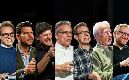 7 Redakteure nebeneinander auf einem Bild zusammengeschnitten. Sie alle spielen ein Videospiel und ziehen eine lustige oder wütende Miene.