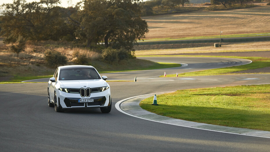 Ein weißer BMW iX3 fährt durch eine Kurve auf der Rennstrecke "Ascari".