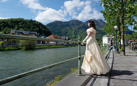 Frau im Sisi-Kostüm blickt auf den Fluss Traun.