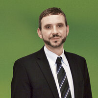 Ein Mann in weißem Hemd und dunklem Anzug mit Krawatte