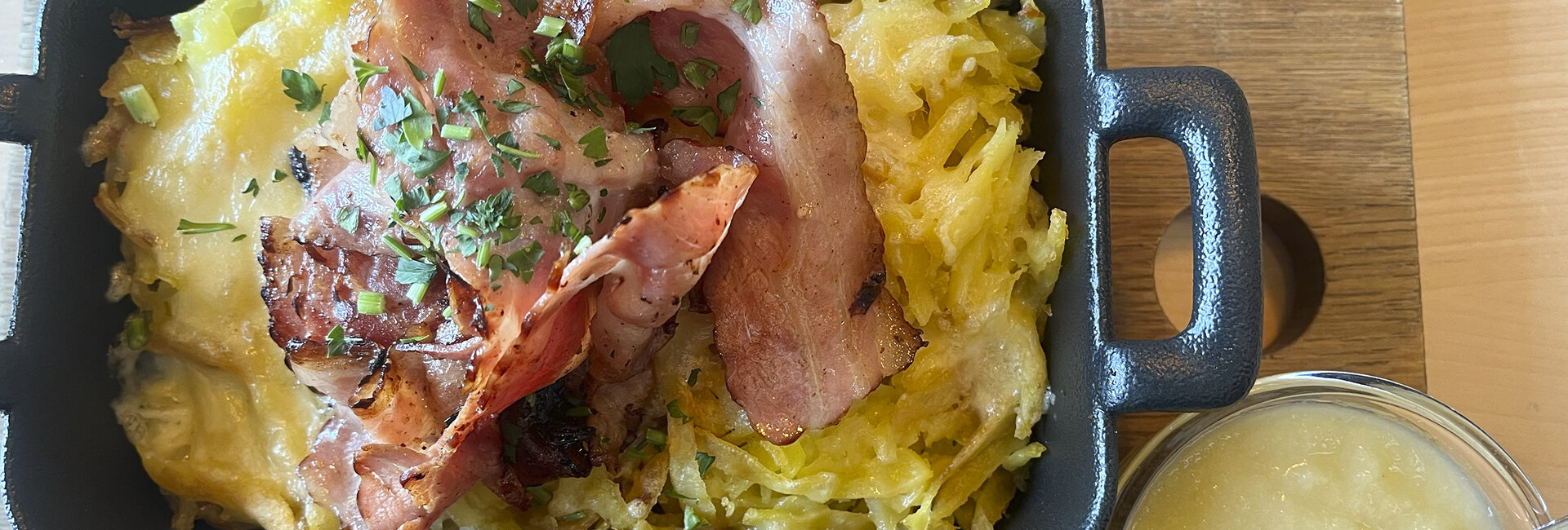 Berner Rösti mit Speck und Apfelmus in einer Eckpfanne.