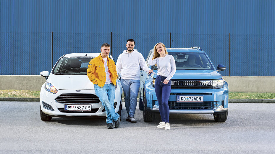 Paul, Marko und Stephanie lehnen an zwei Autos, ein weißer Ford Fiesta und ein grün-grauer Fiat Grande Panda.