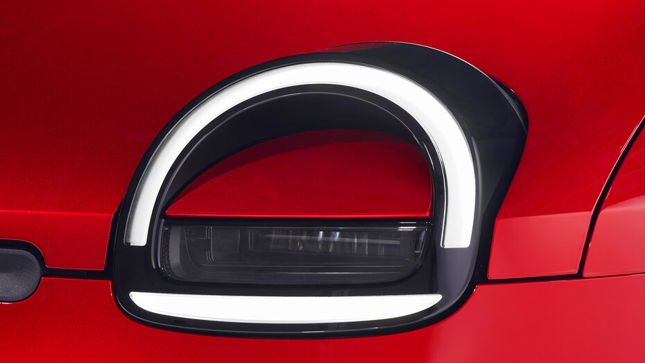 Nahaufnahme der Scheinwerfer eines roten Autos.