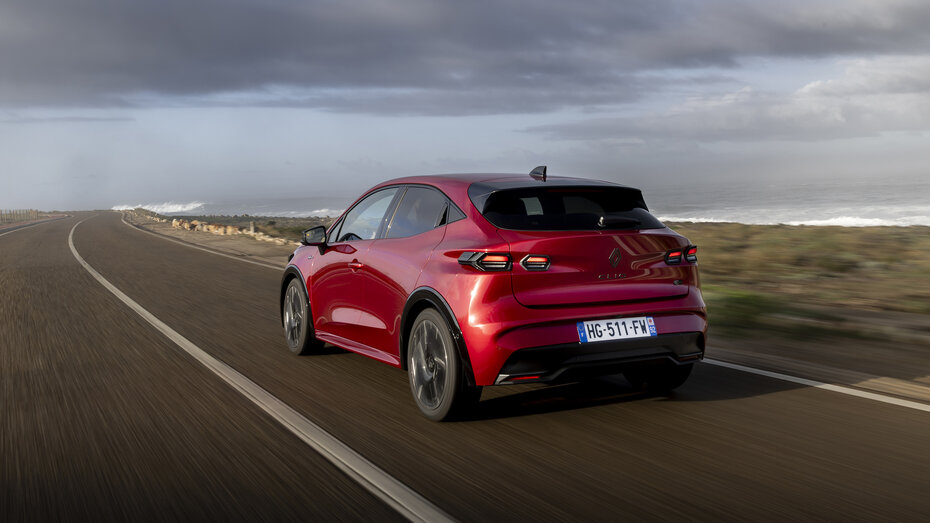 Ein roter Renault Clio fährt auf einer Landstraße.