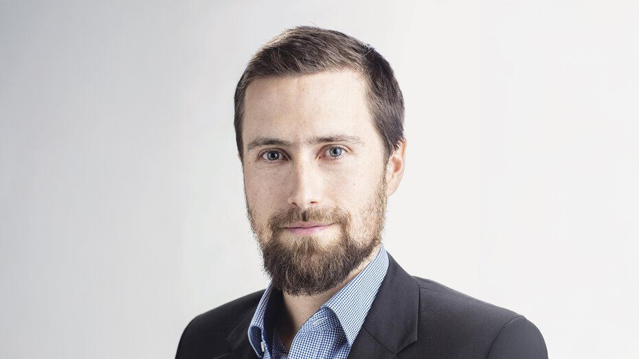 Porträtfoto eines Mannes mit Bart im Anzug