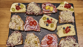 Eine Platte mit zwölf bunt belegten Brötchen.