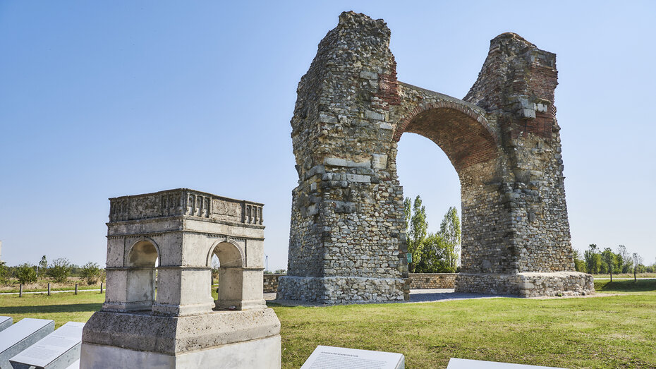 Die Reste des römischen Heidentors. Im Vordergrund ein Modell, das zeigt, dass es einst vier Torbögen gab, die ein Quadrat bildeten.