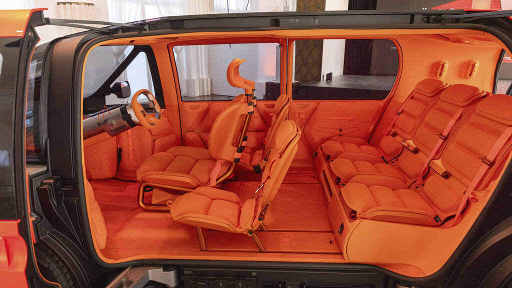 Das Innere des Citroen Elo. Es ist Orange, man sieht alle Sitze, plus die 2 Extra-Sitze neben dem Cockpit.