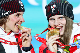 Paraski-Fahrerinnen Elisabeth und Veronika Aigner beißen in ihre Medaillen. 