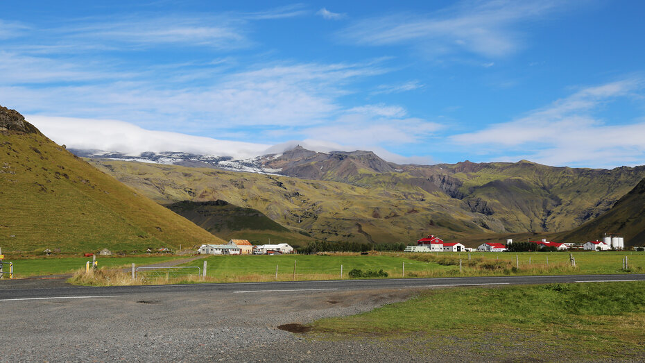 Der Vulkan Eyjafjallajoekull mit einem paar Häusern.