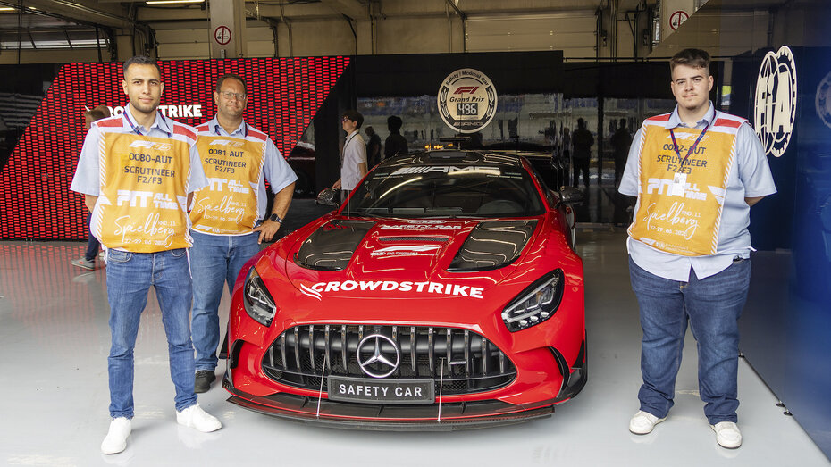 Drei technische Kommentare stehen neben dem Formel-1-Safety-Car.