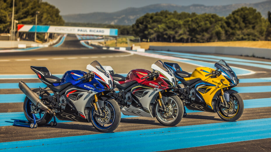 Drei Motorräder stehen auf einer Rennstrecke nebeneinander