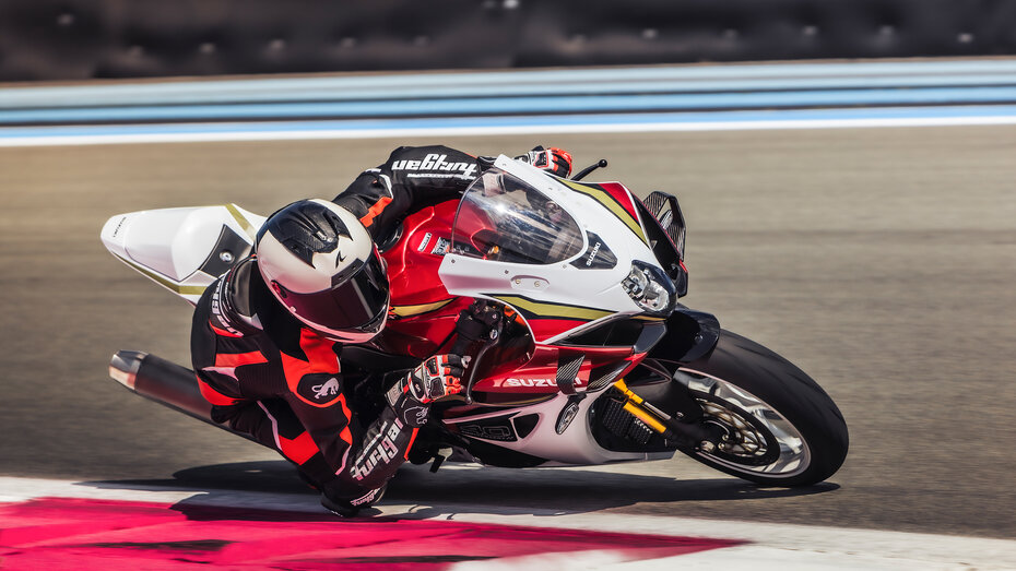 Ein rotes Motorrad fährt auf einer Rennstrecke durch die Kurve