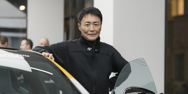 Kazunori Yamauchi an den Polestar 5 gelehnt.