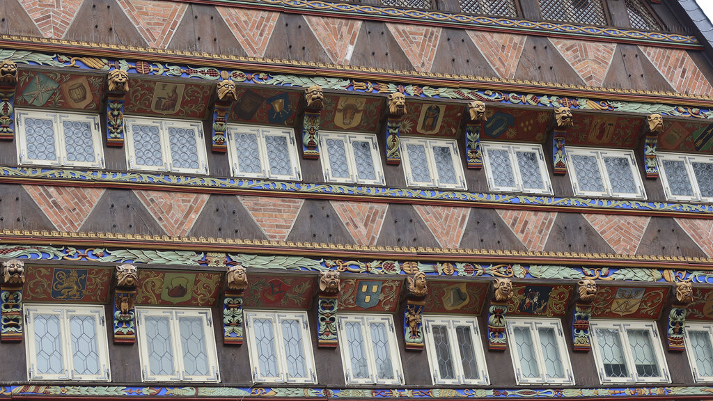 Von bunt bemalten Holzbalken umgebene Fenster.
