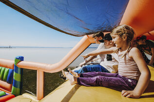 Kinder sitzen auf einer Hüpfburg bereit zu rutschen und spielen.
