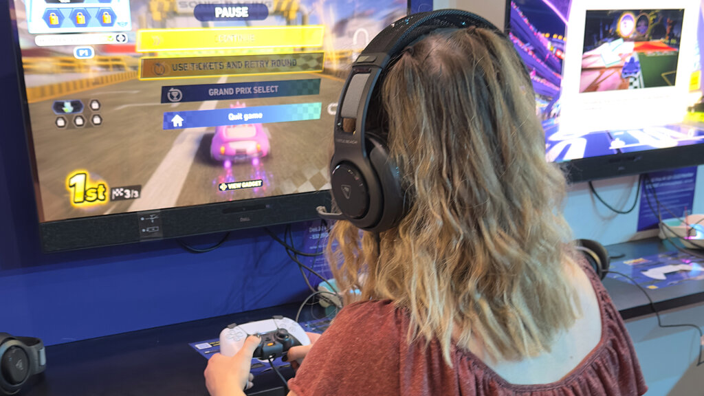 Redakteurin Verena Schauer spielt Sonic Racing: Cross Worlds. Sie hat Kopfhörer auf.