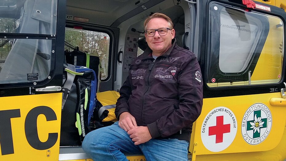Ein ÖAMTC-Mitglied sitzt in der Tür eines Christophorus-Notarzthubschraubers