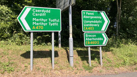 Ein aus dem Auto aufgenommenes Foto, das die komplizierte Sprache walisischer Straßenschilder zeigt.