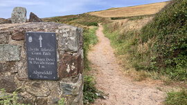 Ein Schild, das den lokalen Beginn des walisischen Küsten-Wanderpfads zeigt.