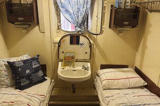 Museum: Eine Kabine am Schiff mit zwei Einzelbetten. In der Mitte ist ein kleines Waschbecken.