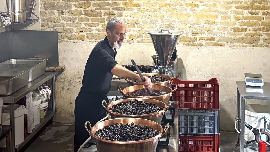 Ein Herr kocht Johannisbeer-Marmelade.