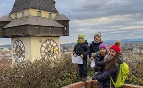 Redakteurin Conny mit ihren Drillingen am Schlossberg in Graz neben dem Uhrturm. 