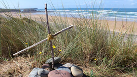 Das Grab-Kreuz des geheimen Grabs der Harry Potter-Figur "Dobby" auf dem Strand von Freshwater West in Wales.