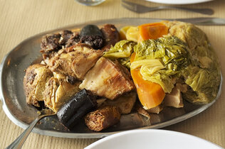 Ein Eintopf mit Fleisch, Blutwurst und Gemüse wie etwa Karotten und Kohl.