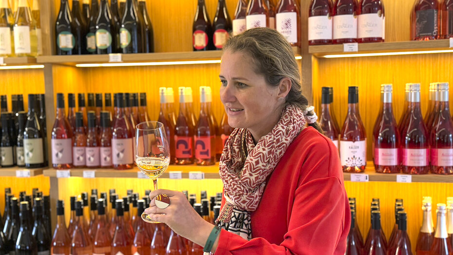 Frau verkostet Wein im Weinshop.