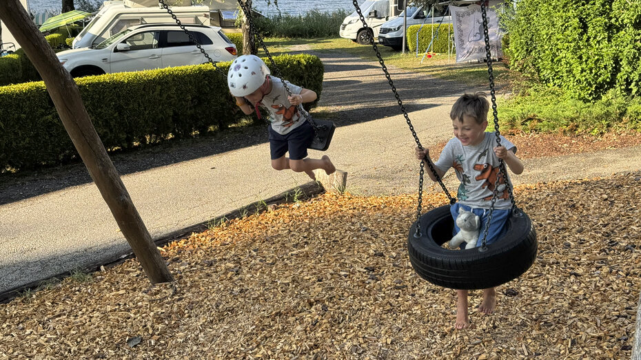 Zwei Buben schaukeln.