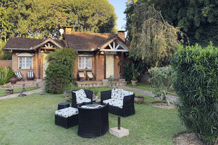 Französiches Cottage mit einer Sitzgelegenheit im Garten.