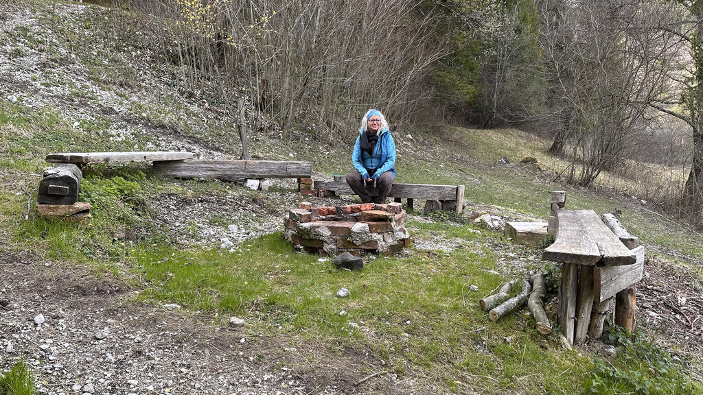 Auszeithof Besitzerin Barbara Enk sitzt in ihrem Garten am Feuerplatz.